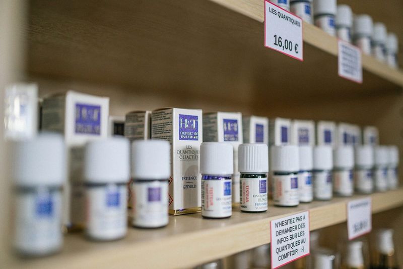 Hvite plastbokser med kosttilskudd på en trehylle