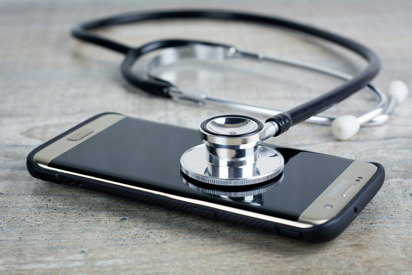 Mobiltelefon med et stetoskop liggende oppå skjermen