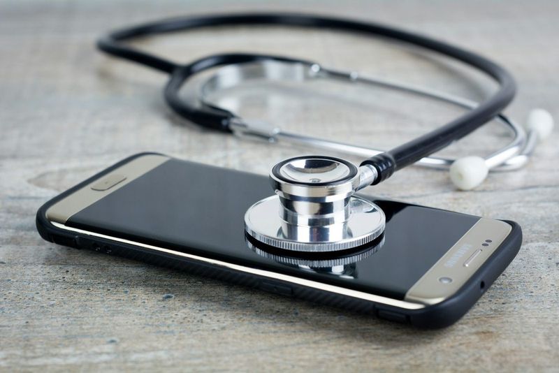 Mobiltelefon med et stetoskop liggende oppå skjermen